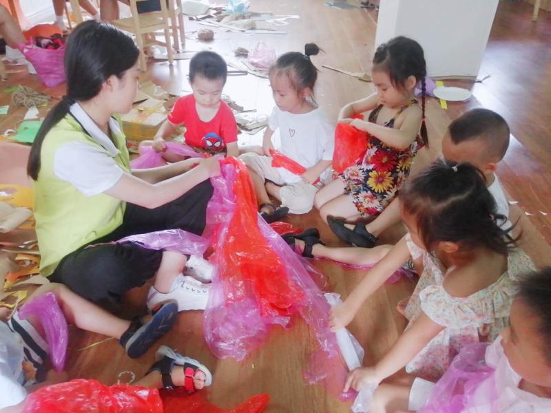 老师带领小朋友用垃圾袋制作裙子.jpg